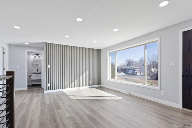 unfurnished living room with recessed lighting, baseboards, visible vents, and wood finished floors