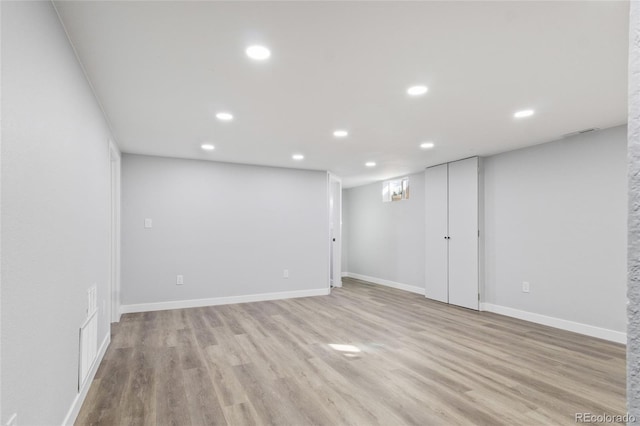 finished below grade area featuring baseboards, recessed lighting, light wood-style flooring, and visible vents