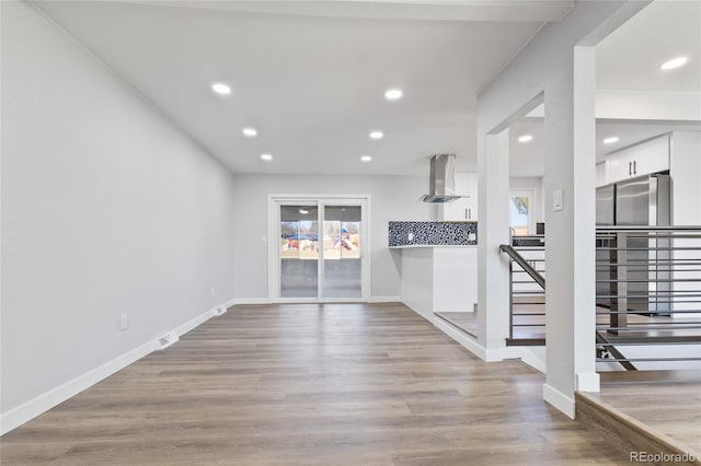 951 E 10th Ave, Broomfield, CO 80020 - unfurnished living room with healthy amount of natural light, baseboards, wood finished floors, and recessed lighting