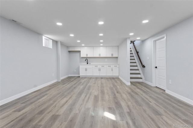 951 E 10th Ave, Broomfield, CO 80020 - unfurnished living room with recessed lighting, baseboards, light wood finished floors, stairway, and bar