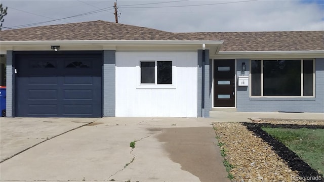 951 E 10th Ave, Broomfield, CO 80020 - view of front facade with brick siding, roof with shingles, driveway, and an attached garage