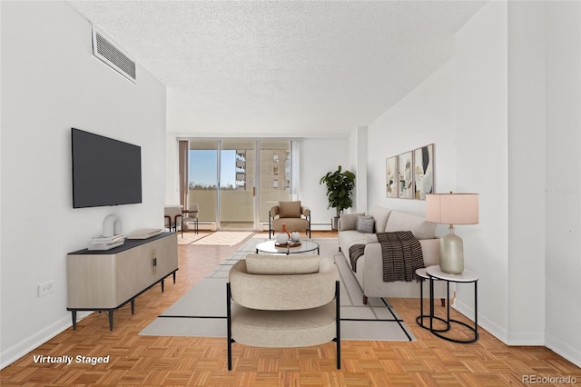 living room with light parquet flooring, floor to ceiling windows, and a textured ceiling