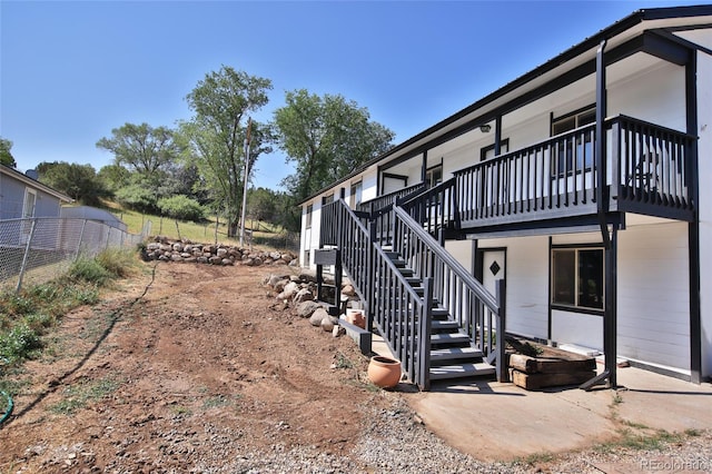 view of property exterior with stairway and fence