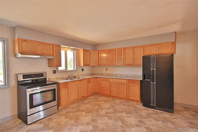 kitchen featuring light brown cabinetry, black fridge, stainless steel electric range oven, and under cabinet range hood