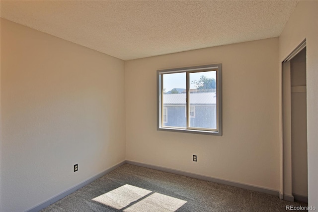 unfurnished bedroom with baseboards, a textured ceiling, and dark carpet