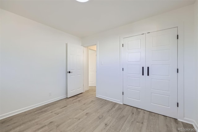 unfurnished bedroom with a closet and light wood-type flooring