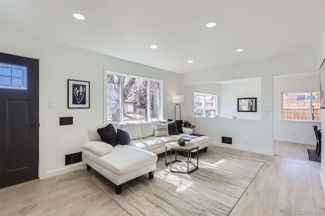 living area featuring light wood-style flooring, visible vents, baseboards, and recessed lighting