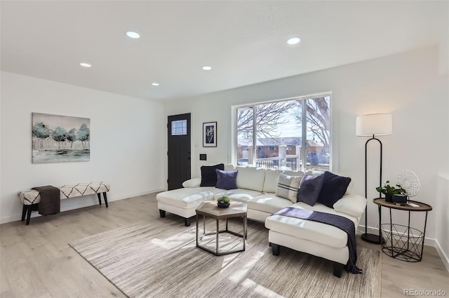 living area with baseboards, light wood-style flooring, and recessed lighting