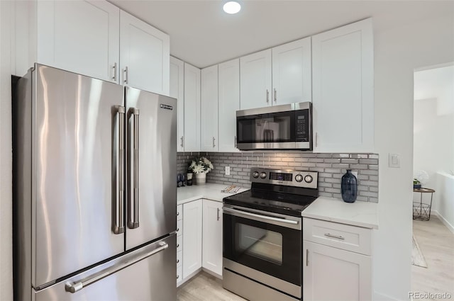 kitchen with tasteful backsplash, white cabinetry, and stainless steel appliances