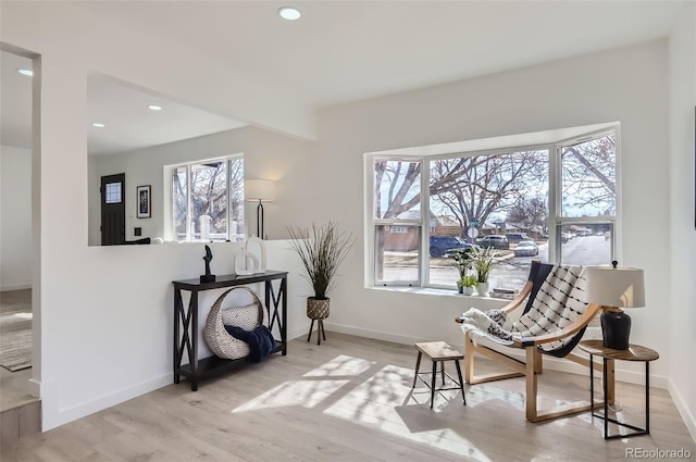 living area featuring a healthy amount of sunlight, light wood-style floors, baseboards, and recessed lighting