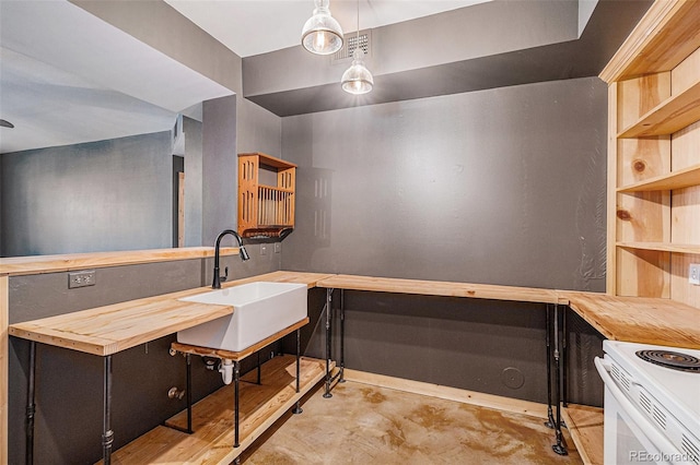 kitchen featuring wooden counters, decorative light fixtures, and sink