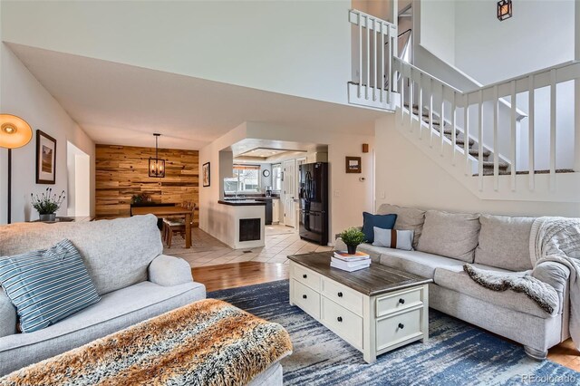 living area with wood walls and stairs
