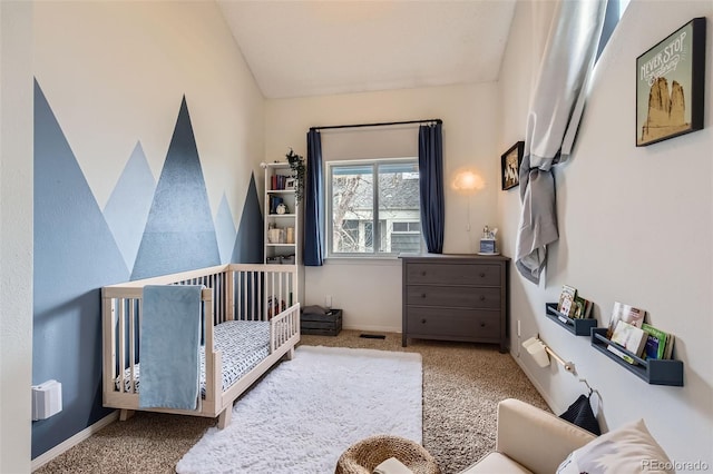 carpeted bedroom featuring baseboards, a crib, and lofted ceiling