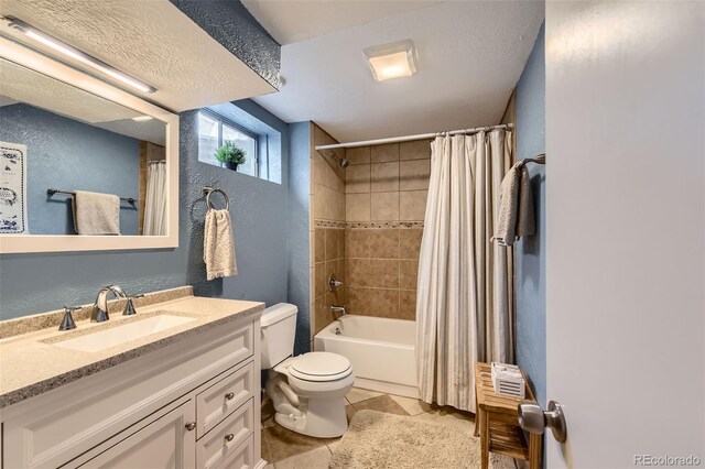 bathroom with tile patterned flooring, shower / tub combo, vanity, toilet, and a textured wall