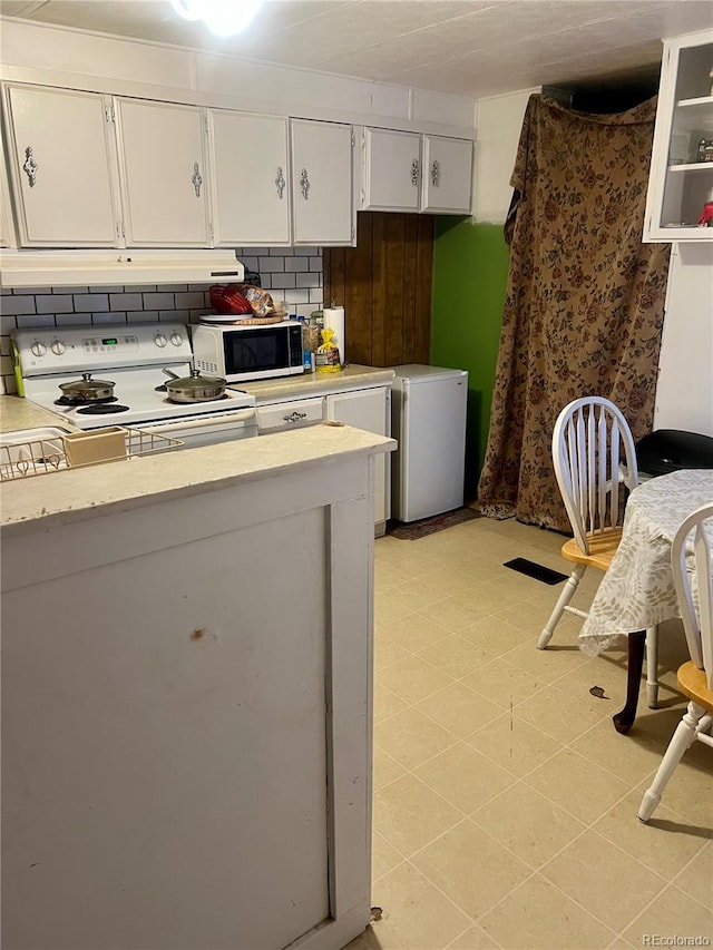 kitchen with white cabinets, white appliances, and tasteful backsplash