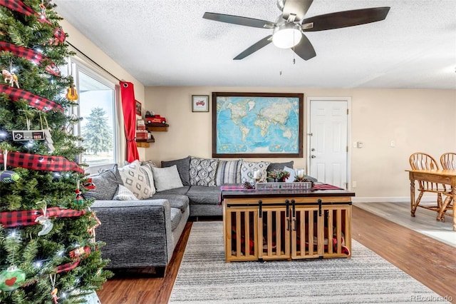 living room featuring a textured ceiling, hardwood / wood-style flooring, and ceiling fan