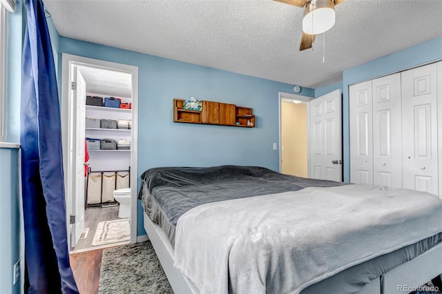 bedroom with hardwood / wood-style flooring, ceiling fan, a textured ceiling, connected bathroom, and a closet