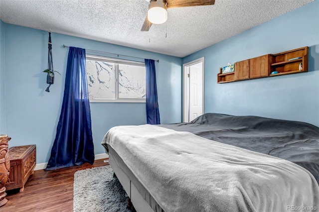 bedroom featuring a textured ceiling, ceiling fan, and dark wood-type flooring