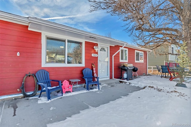 snow covered property featuring a patio area