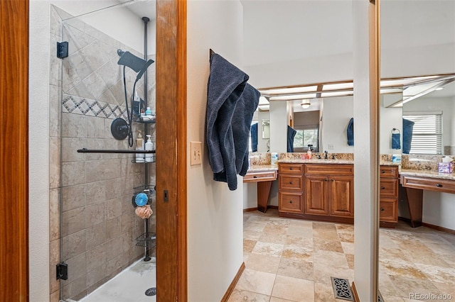 full bath featuring vanity, baseboards, and a stall shower