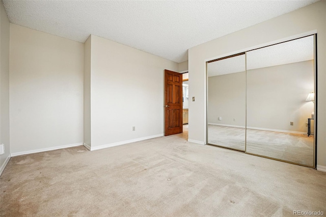 unfurnished bedroom with a closet, a textured ceiling, baseboards, and carpet floors