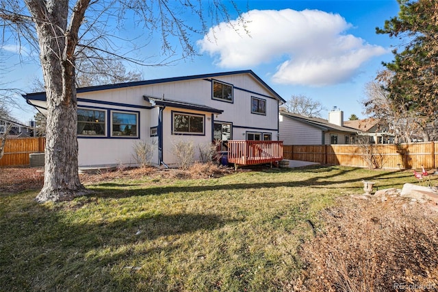 back of property featuring a lawn, central AC, a deck, and fence