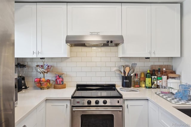kitchen featuring stainless steel electric range oven, white cabinets, light countertops, range hood, and tasteful backsplash
