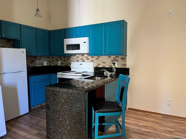 kitchen with blue cabinets, white appliances, backsplash, and a peninsula