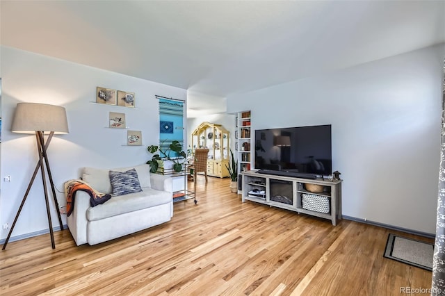 living area featuring baseboards and light wood-style flooring
