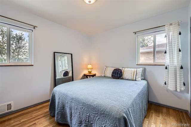 bedroom featuring wood finished floors and visible vents