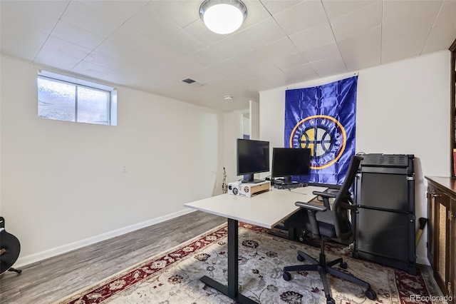 office area featuring baseboards, wood finished floors, and visible vents