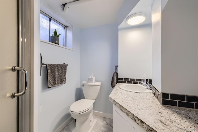 bathroom featuring toilet, baseboards, marble finish floor, and vanity