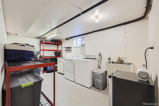 laundry area with laundry area, washer and clothes dryer, and a sink