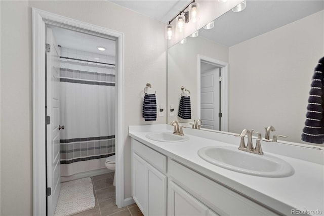 bathroom featuring tile patterned flooring, vanity, toilet, and walk in shower