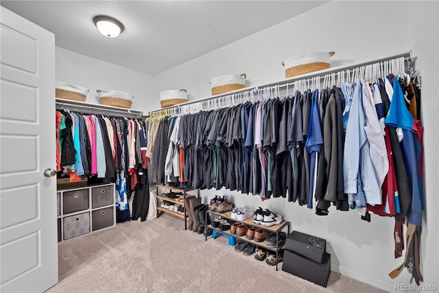 walk in closet featuring light colored carpet