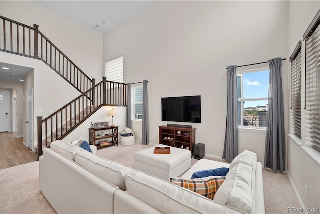 living room with a high ceiling and light hardwood / wood-style flooring