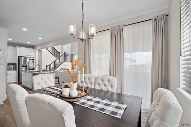 dining area featuring dark hardwood / wood-style flooring, an inviting chandelier, and sink