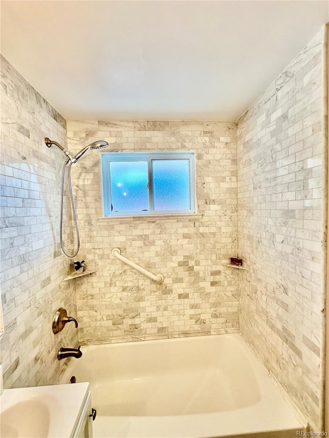 bathroom featuring vanity and tiled shower / bath