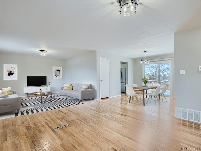 living room featuring light hardwood / wood-style floors and a chandelier