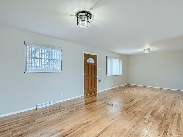 interior space featuring a baseboard radiator and light hardwood / wood-style flooring