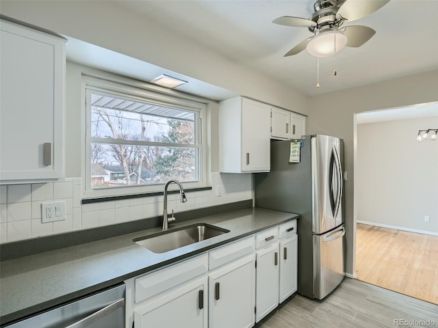 kitchen featuring white cabinetry, appliances with stainless steel finishes, sink, and backsplash