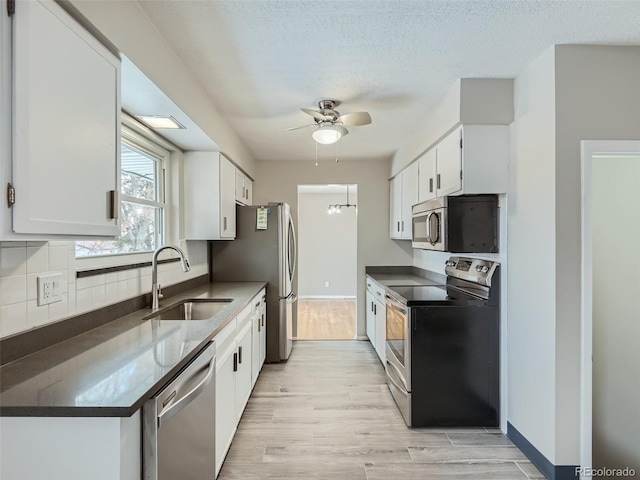 kitchen with white cabinetry, stainless steel appliances, sink, and decorative backsplash