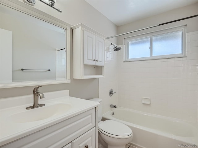 full bathroom with tiled shower / bath, vanity, and toilet