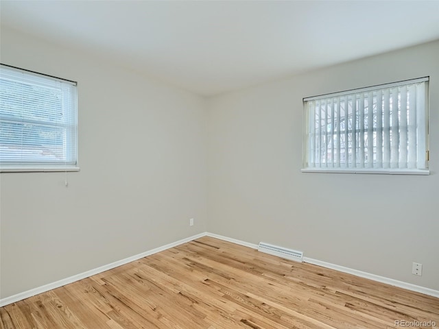 empty room with light hardwood / wood-style flooring