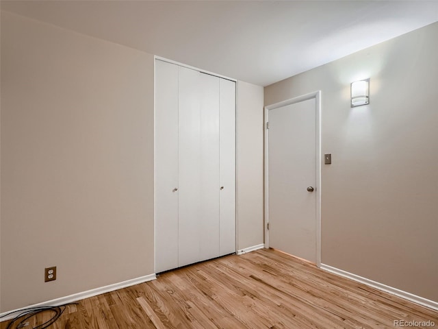 unfurnished bedroom featuring light hardwood / wood-style flooring and a closet