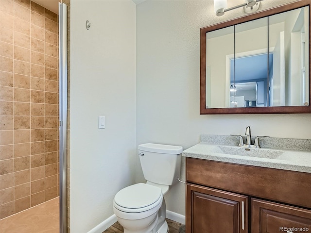 bathroom featuring vanity, toilet, and a shower with door