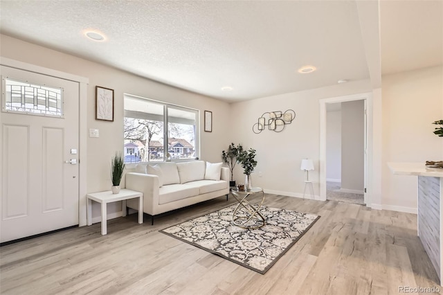 living room with a textured ceiling and light hardwood / wood-style floors