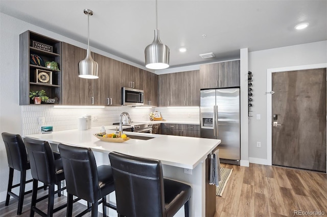 kitchen with a kitchen breakfast bar, kitchen peninsula, and appliances with stainless steel finishes