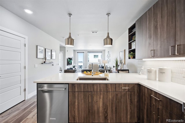 kitchen with dark brown cabinetry, sink, tasteful backsplash, and hanging light fixtures