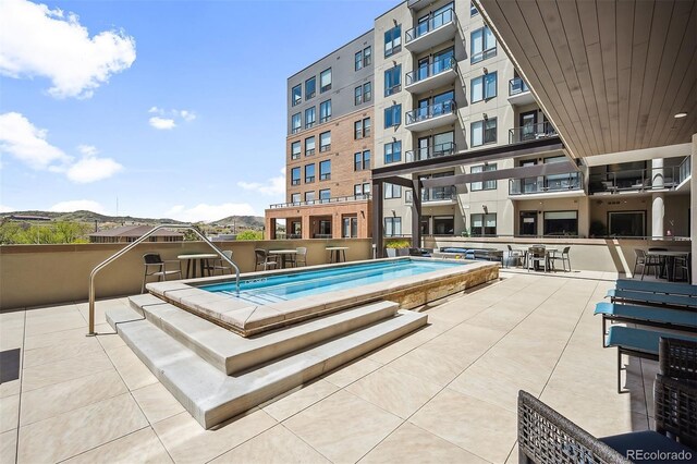 view of pool featuring a mountain view and a patio